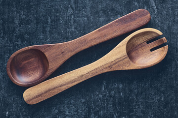 Wooden spoons in vintage style lie diagonally on a gray background. Kitchen utensils, close up