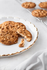 Peanut cookies on a white plate. Tea and golden spoon in the background.