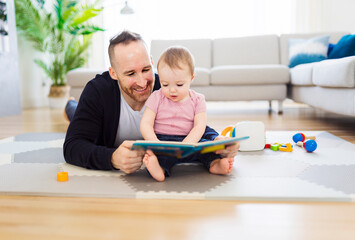 a happy man with baby reading book