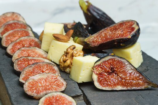 tabla de brevas, frutos secos y queso en piedra.