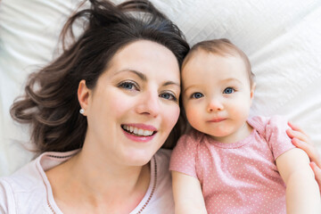 happy family. Mother and baby playing and smiling under a blanket