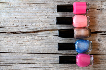 Colorful, bright and glittery nail polish bottles on a wooden background.Manicure tools, beauty, nail art concept. 