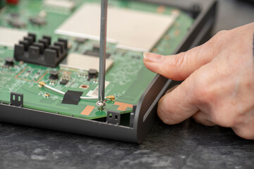 Destornillador aprieta un tornillo de un aparato eléctrico