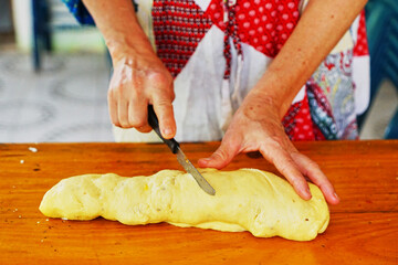 Manos de mujer cortando la masa para hacer pan o pan dulce 