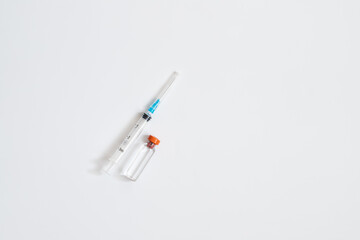 Syringe And Bottle With Liquid On White Background With Copyspace.