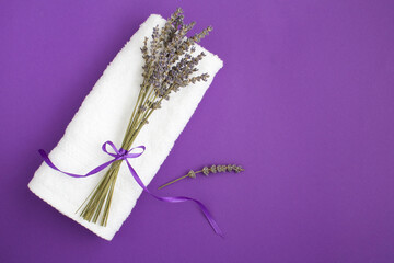 Top view of white  towel and dry lavender bouquet on the violet background