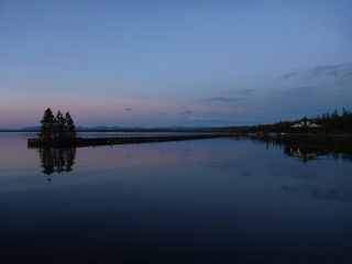 Pink and purple sky colors reflected in a lake at yellowstone national park at twilight