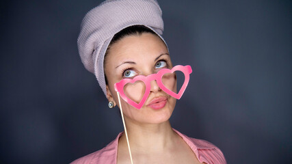 Portrait of a woman with heart-shaped glasses on a stick. Negative space or copy space for text.