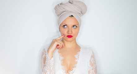 Portrait of  Caucasian woman with turban on her head, touching cheek with finger. Copy space.