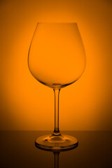 Vine glass on reflecting surface over backdrop, studio advertising shot, copy space