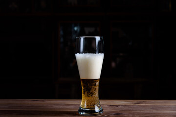 Glass with beer on a wooden table.