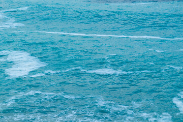 beautiful, blue sea with waves and foam in good weather during the day
