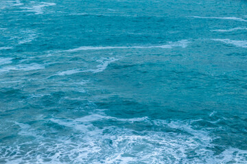 beautiful, blue sea with waves and foam in good weather during the day
