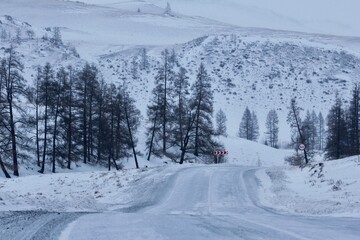 Road in the mountains in gloomy winter morning