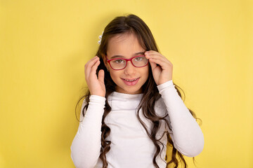 Fototapeta premium Funny child girl in glasses on colored background