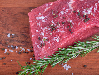 beef with rosemar and spicery on wood background