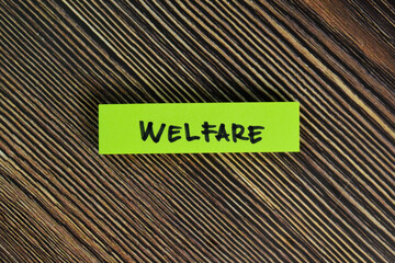 Welfare write on sticky notes isolated on Wooden Table.