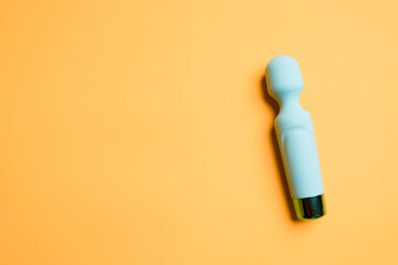 Blue vibrator or masturbation massager on an orange background. Flat Lay. Sex shop concept