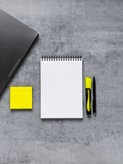 Laptop, phone, and office supplies on a gray concrete table. Workplace. A study table. Remote work. Distance learning. uminous yellow and extremely gray. The color of 2021. Copy space
