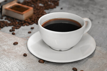 Close up of a cup of coffee surrounded with coffee beans. Vintage style.Loft