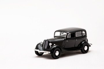 Fototapeta premium Miniature model of a retro car on a white background. A toy car model. Vintage car model.