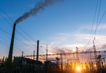 distribution electric substation with power lines and transformers, at sunset