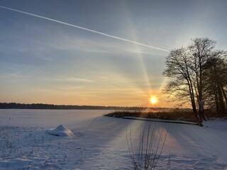 View of the frozen Białe lake near Włodawa with a large amount of snow view of the reeds just before sunset elephant, sun orange golden hour