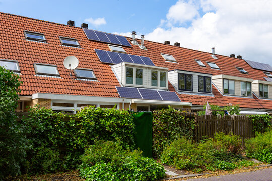 Solarpannels on the orange tiled roof of a terraced house with a dormer in the South-Holland village of Sassenheim in the Netherlands.