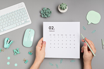 Desktop with calendar for february and office supplies. home office, social media blog, schedule,...