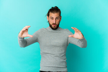 Young man with long hair look holding something with palms, offering to camera.