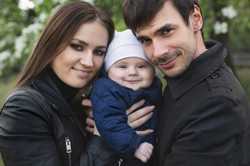 Fototapeta premium Beautiful smiling faces of people. A happy young family from three persons