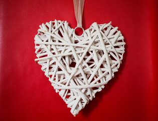 White wooden heart on red background for Valentine day