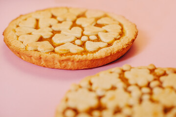 Delicious fragrant pies on a pink background.
