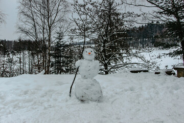 Funny handmade snowman with carrot nose in winter park. Christmas or xmas decoration. Happy holiday...