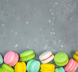 Bright pastries macarons on a gray background.