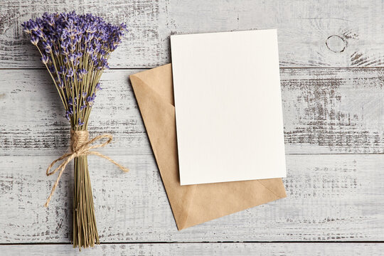 Greeting card mockup with envelope and dry lavender flowers on wooden background