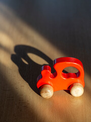 Red toy car on wooden surface