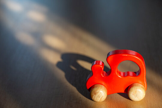 Red toy car on wooden surface