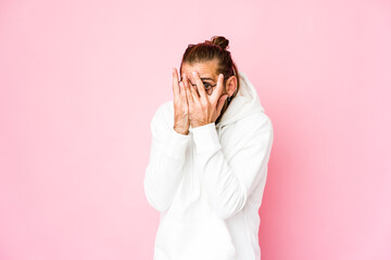 Young man with long hair look blink through fingers frightened and nervous.