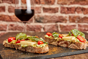 Brusquetas Caprese with a glass of wine.