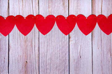 Red hearts garland love on wooden background. Top view with copy space