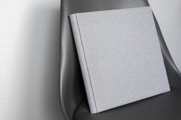 amily photo book.
stylish Photo album on chair .
grey photobook with  leather cover.
Beautiful photoalbum with hard  fabric cover on background .
Pastel wedding photo album with copy space for text.