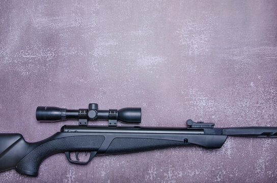 pneumatic rifle on concrete background. Top view with copy space