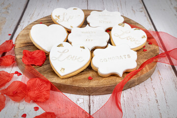 Wedding-themed cookies displayed on a wooden board