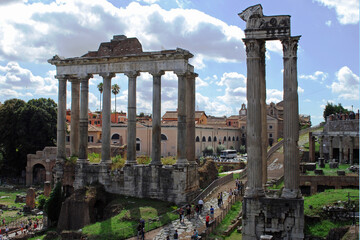 Late day sunlight creates long shadows of all that remain of a couple of ancient buildings in the Forum in Rome