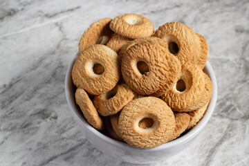 Ring Coconut biscuits served in a bowl. Brazilian little donut. Selective focus.
