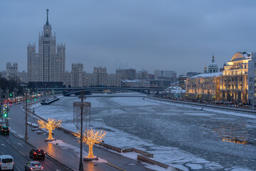 Evening urban landscape with a river and a high tower