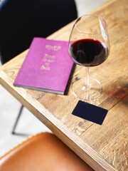 glass of wine on wooden table with wine card menu