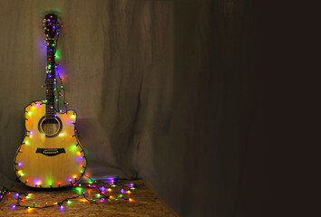 Acoustic guitar with bright illumination on dark drapery. Concert poster, poster, poster. business card