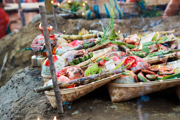 holy offerings of fruits flowers lamps and cloths in river to sun god on the occasion of chhath...
